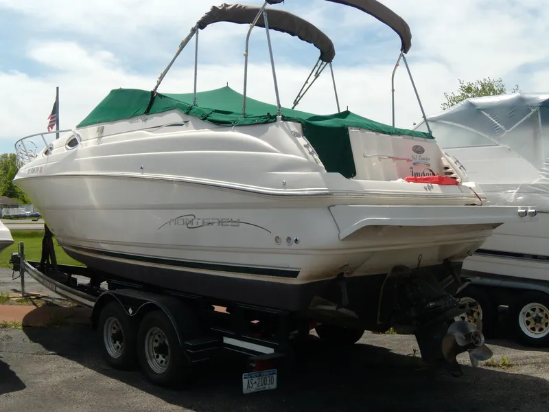 Slide: The Image of 2001 Monterey 262 Cruiser boat on Loadmaster trailer, parked outdoors. - 10