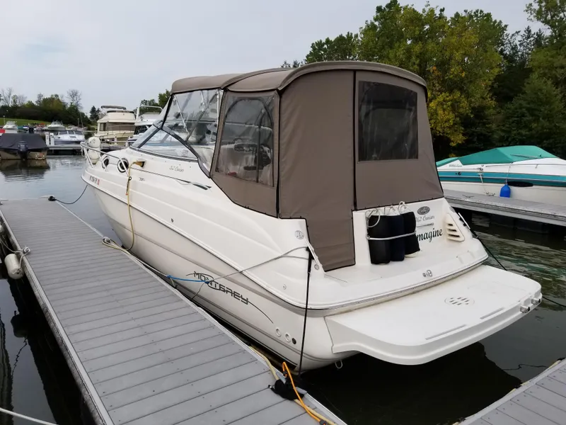 Slide: The Image of 2001 Monterey 262 Cruiser boat docked in a marina, surrounded by other boats. - 2
