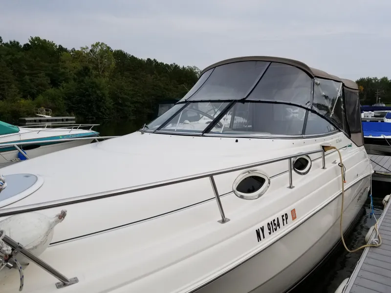 Slide: The Image of 2001 Monterey 262 Cruiser docked at marina, featuring beige canopy and sleek design. - 3
