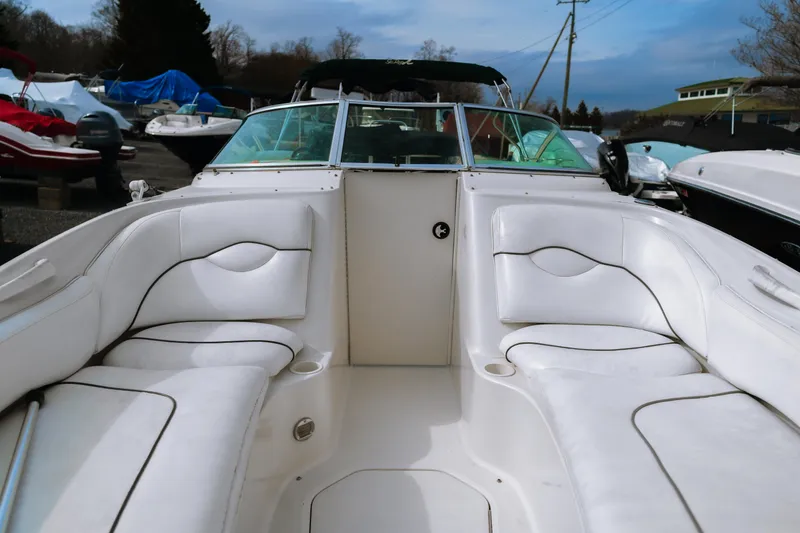 Slide: The Image of 2003 Sea Ray 240 Sundeck boat interior with white seating and open deck layout. - 7