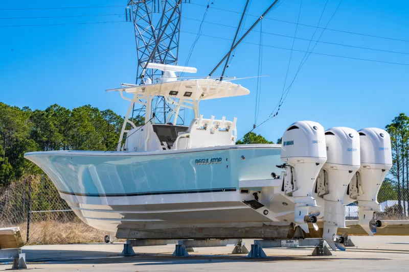 Slide: The Image of 2019 Regulator 34 boat with triple Yamaha engines on a sunny day. - 1