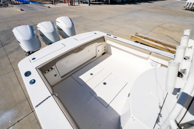 Slide: The Image of 2019 Regulator 34 boat deck with triple outboard engines, spacious layout, and storage compartments. - 10
