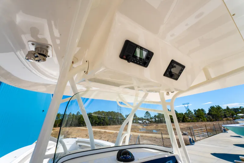 Slide: The Image of 2019 Regulator 34 boat console with electronics, white structure, and clear blue sky background. - 15