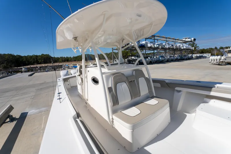 Slide: The Image of 2019 Regulator 34 boat with seating and canopy, parked in a marina under clear blue sky. - 17