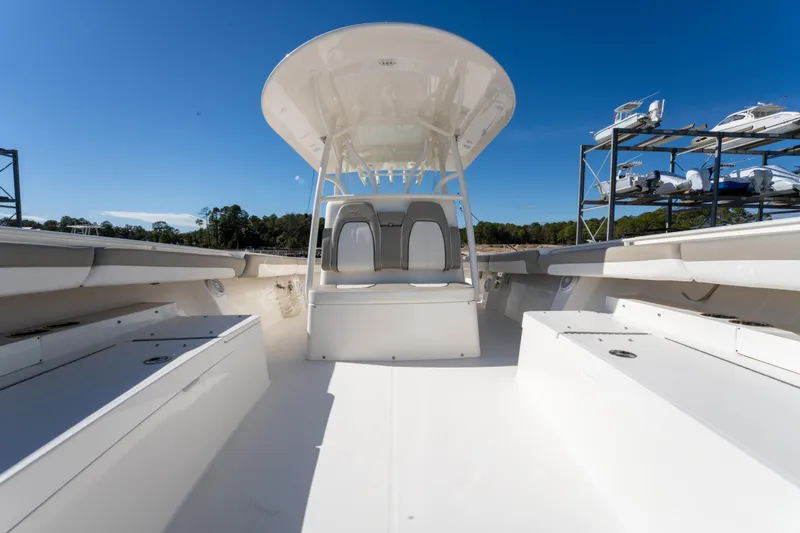 Slide: The Image of 2019 Regulator 34 boat interior with seating and storage, under clear blue sky. - 18