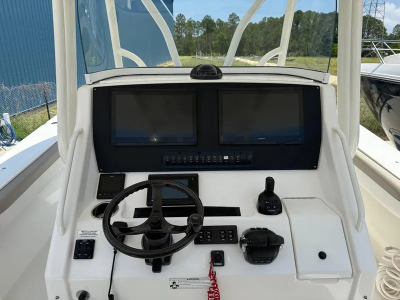 Slide: The Image of Control console of a 2019 Regulator 34 boat with dual screens and steering wheel. - 32