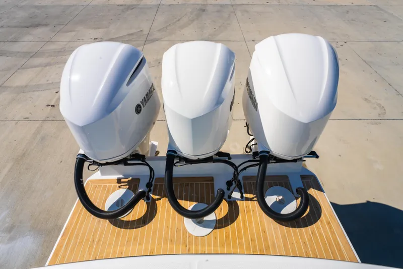 Slide: The Image of 2019 Regulator 34 boat with three Yamaha outboard engines on a wooden deck. - 8