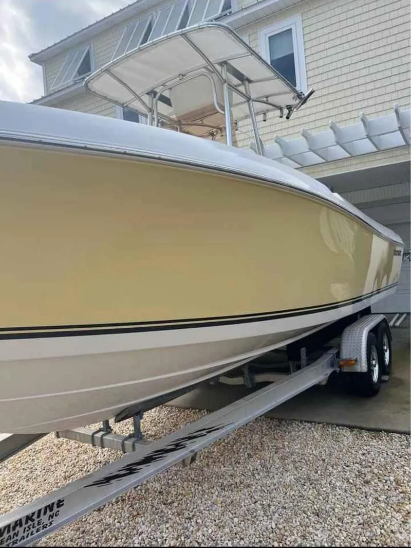 Slide: The Image of 2008 Clearwater 2500 boat on trailer, parked near a house, showcasing sleek yellow hull design. - 3