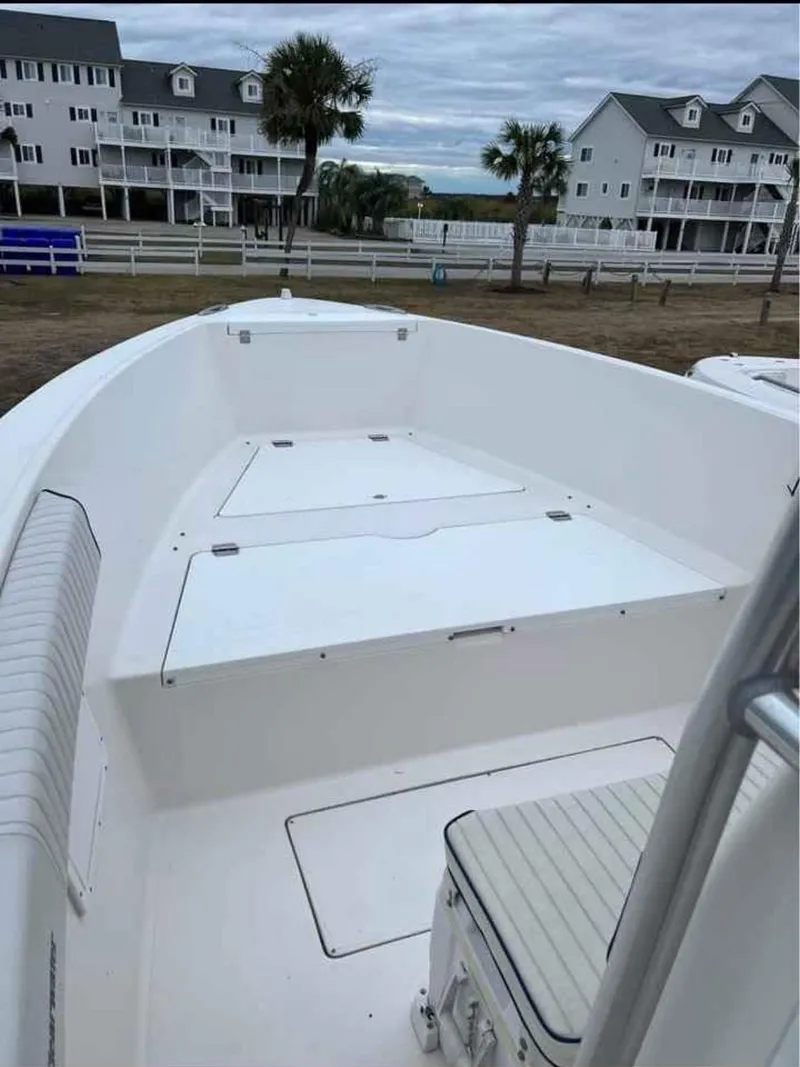 Slide: The Image of 2008 Clearwater 2500 boat with spacious deck, docked near coastal homes. - 8