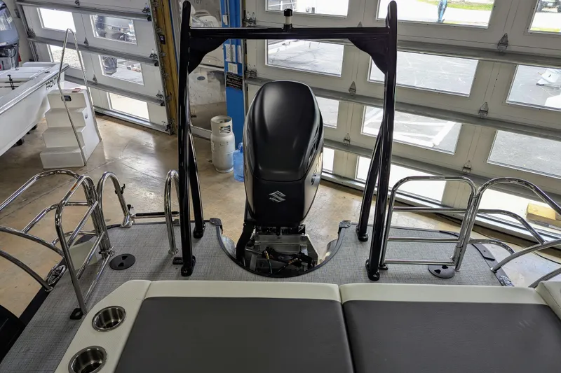 Slide: The Image of 2026 Trifecta 23UL SS ARCH boat interior with motor, ladder, and seating in a showroom. - 13