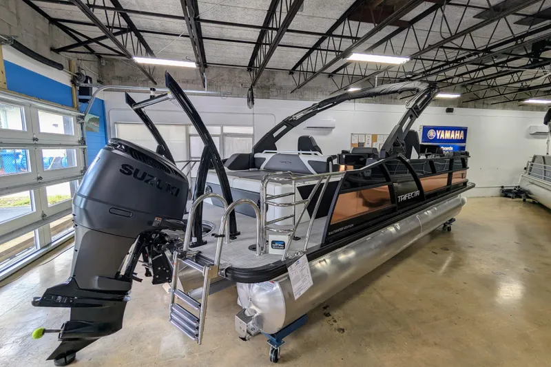 Slide: The Image of 2026 Trifecta 23UL SS ARCH pontoon boat with Suzuki engine in showroom. - 2