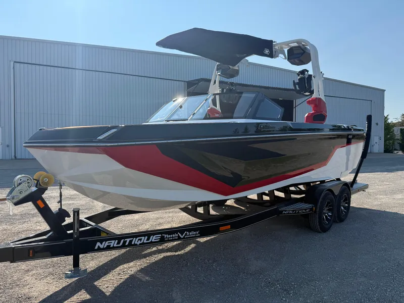 Slide: The Image of 2025 Nautique Super Air Nautique GS22 boat on trailer, sleek design, red and black accents. - 0