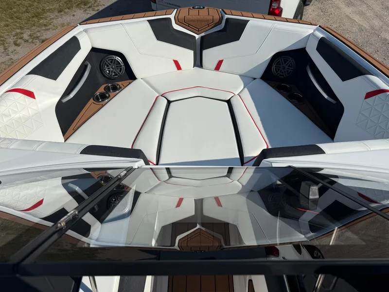 Slide: The Image of 2025 Nautique Super Air Nautique GS22 interior with white seating, red accents, and cup holders. - 19