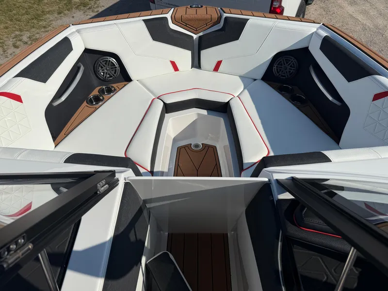 Slide: The Image of 2025 Nautique Super Air Nautique GS22 boat interior with white seating, cup holders, and speakers. - 20