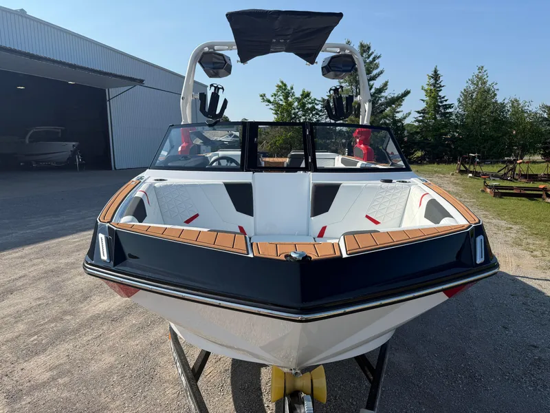 Slide: The Image of 2025 Nautique Super Air Nautique GS22 boat with sleek design, parked outdoors. - 8