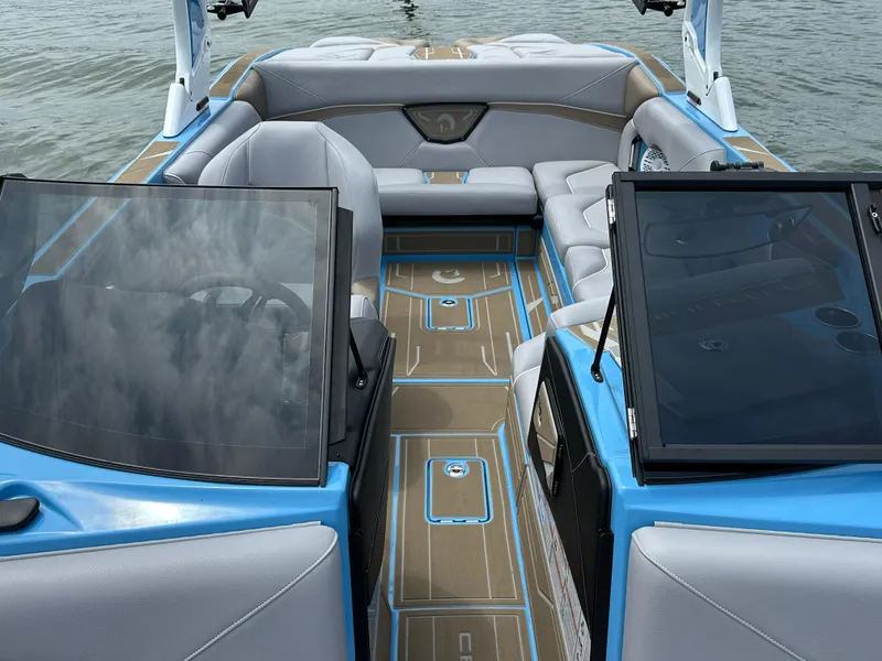 Slide: The Image of 2025 Centurion NV233 boat interior with modern seating and sleek design on the water. - 13