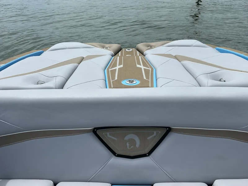 Slide: The Image of 2025 Centurion NV233 boat interior with sleek seating design on calm water. - 15