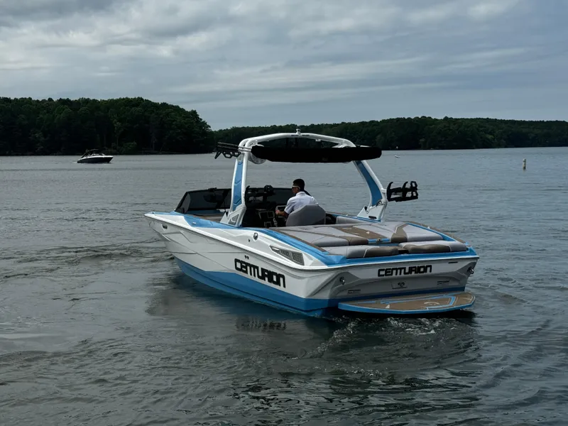 Slide: The Image of 2025 Centurion NV233 boat cruising on a lake under cloudy skies. - 3