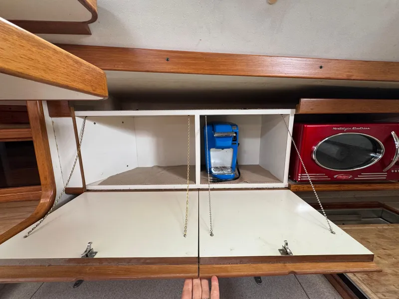 Slide: The Image of Cabinet interior of a 1995 Catalina 400 yacht with coffee maker and red microwave. - 11