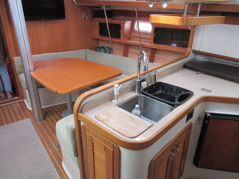Slide: The Image of Interior of 1995 Catalina 400 sailboat with kitchen and dining area. - 14