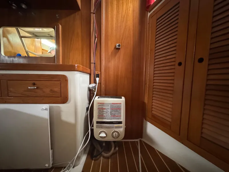 Slide: The Image of Interior of a 1995 Catalina 400 sailboat featuring wooden cabinetry and a compact heater. - 18