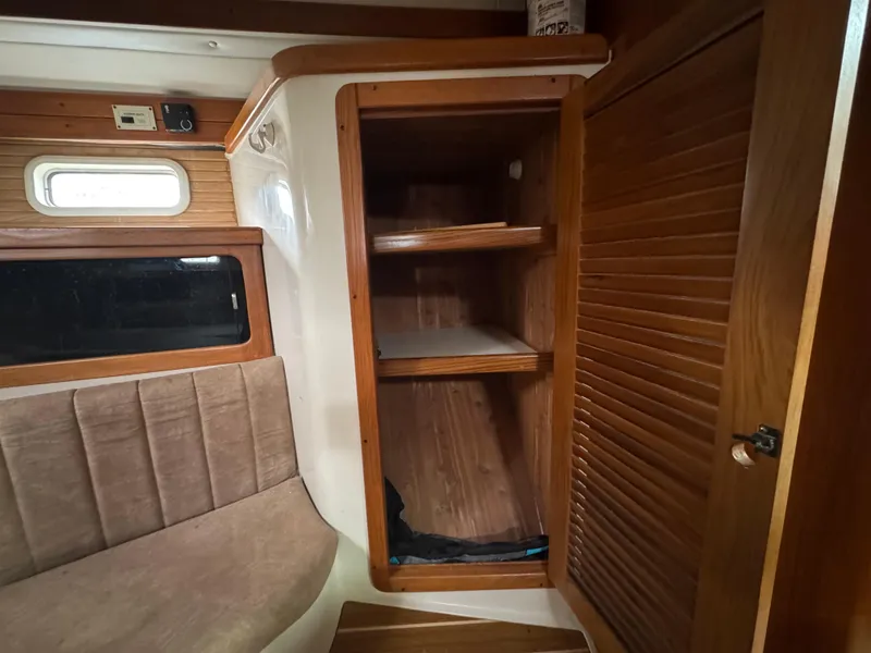 Slide: The Image of Interior of a 1995 Catalina 400 sailboat with wooden shelves and seating. - 19