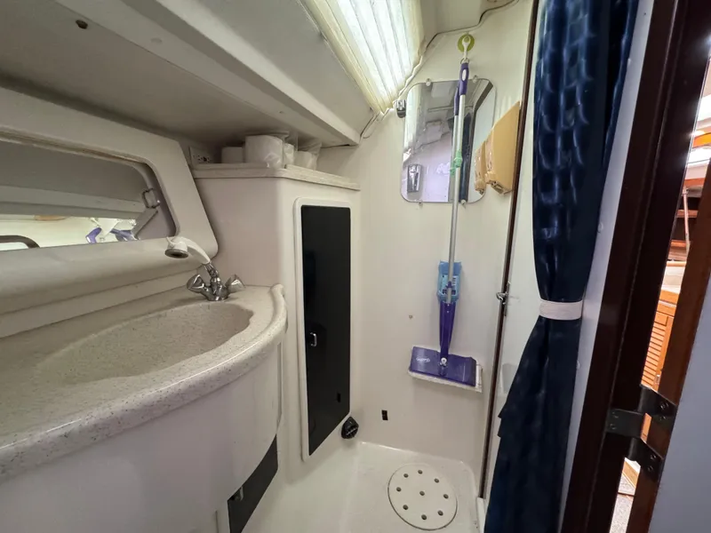 Slide: The Image of Interior of 1995 Catalina 400 sailboat bathroom with sink, mirror, and cleaning supplies. - 20