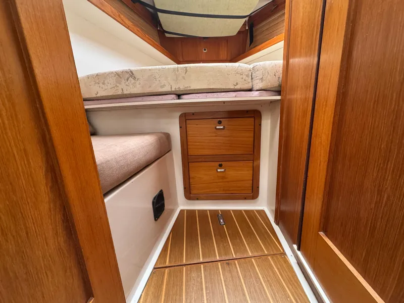 Slide: The Image of 1995 Catalina 400 yacht interior with wooden cabinetry and cozy sleeping area. - 24
