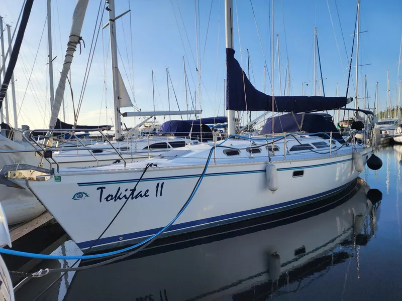 Slide: The Image of Catalina 400 sailboat, 1995 model, docked in marina with blue accents and sails. - 3