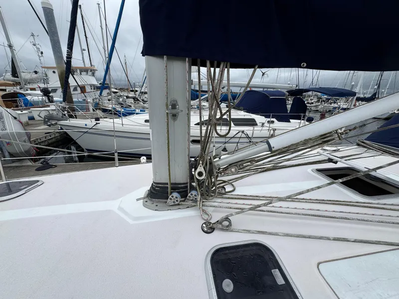 Slide: The Image of Sailboat deck view of a 1995 Catalina 400 in a marina, showcasing rigging and nearby boats. - 37