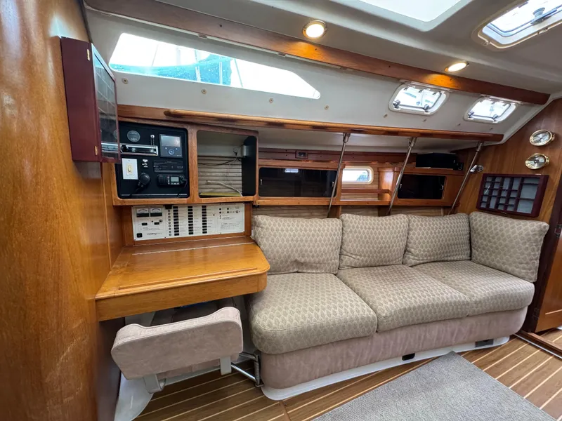 Slide: The Image of Interior of a 1995 Catalina 400 sailboat with a cozy sofa and navigation station. - 5