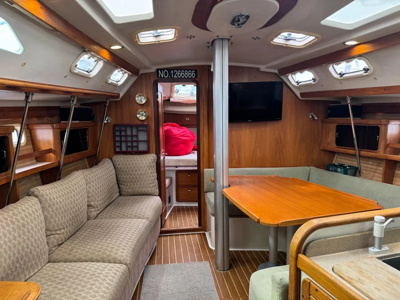 Slide: The Image of Interior of a 1995 Catalina 400 sailboat with cozy seating and wooden finishes. - 7