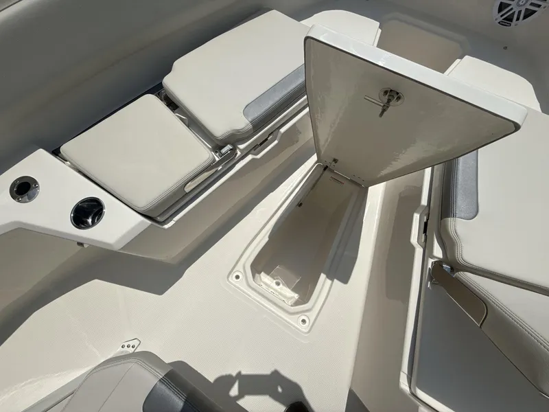 Slide: The Image of 2025 Sailfish 232 CC boat interior with open storage compartment and cushioned seating. - 11