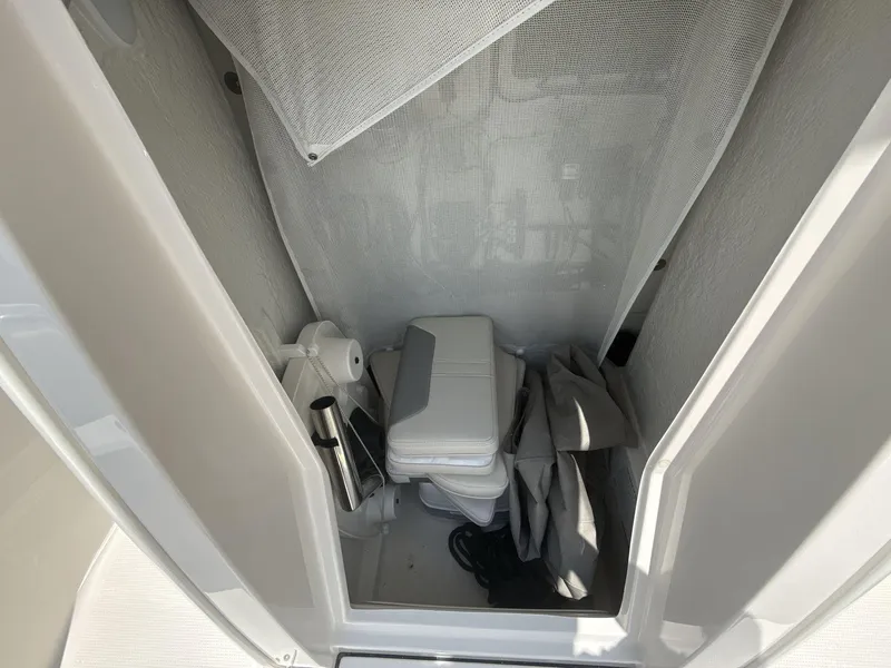 Slide: The Image of 2025 Sailfish 232 CC boat interior with compact toilet and storage area. - 14