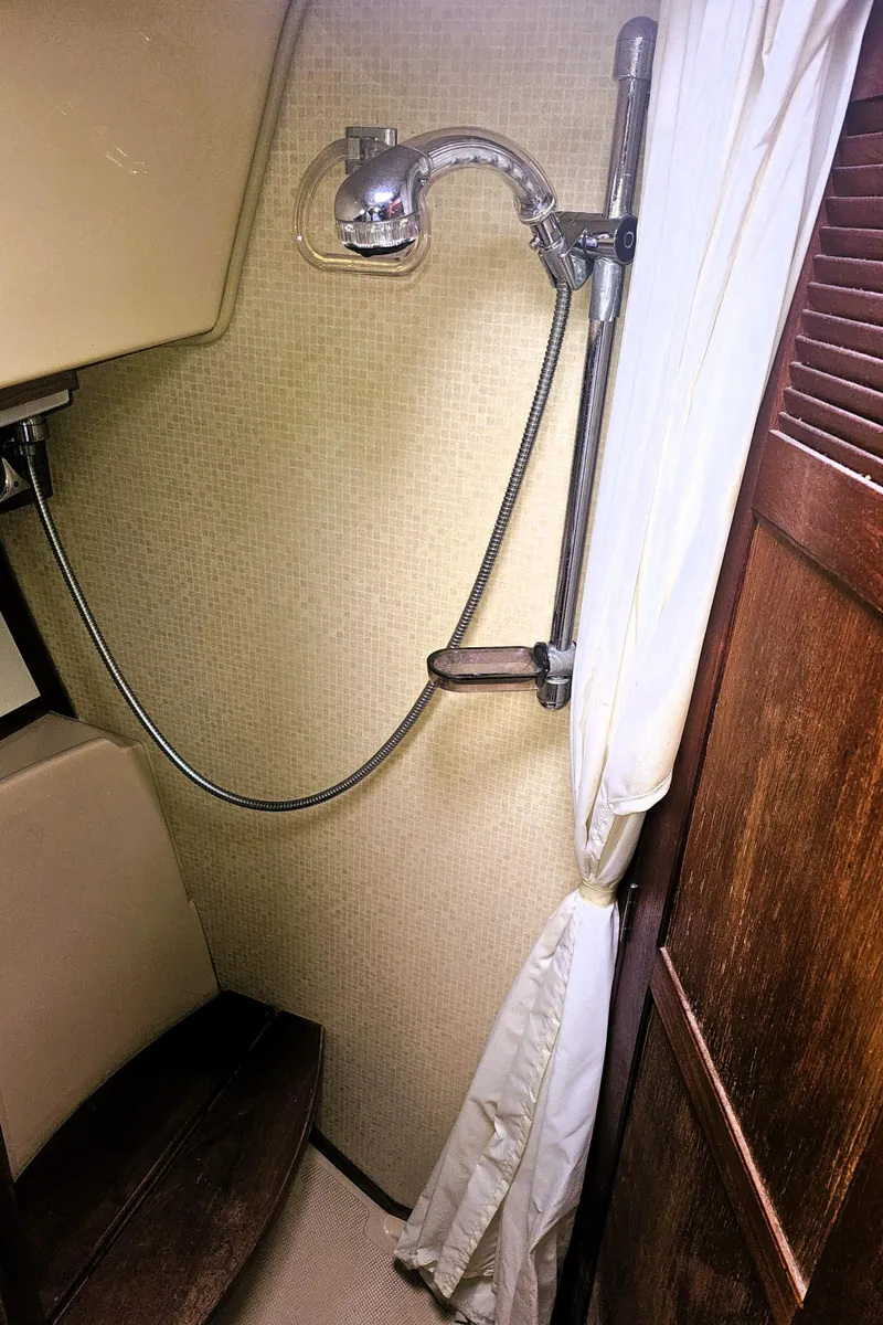 Slide: The Image of 1990 Island Packet 35 sailboat shower area with curtain and handheld showerhead. - 12