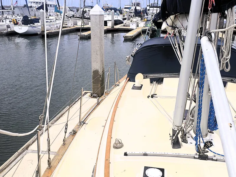 Slide: The Image of 1990 Island Packet 35 sailboat docked at marina, showcasing deck and rigging. - 19
