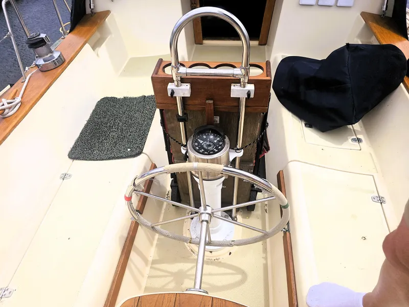 Slide: The Image of Cockpit of 1990 Island Packet 35 sailboat with steering wheel and compass. - 24
