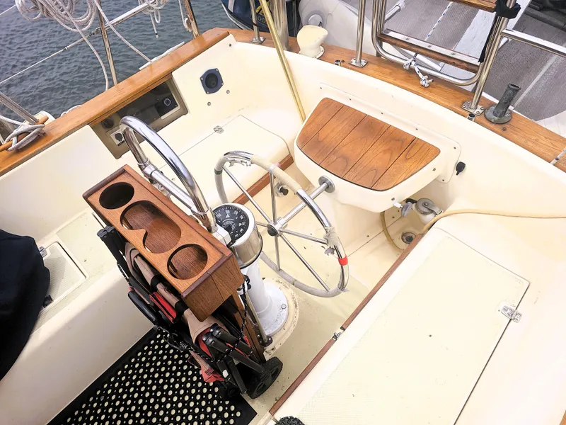 Slide: The Image of Cockpit of 1990 Island Packet 35 sailboat with steering wheel and wooden accents. - 25