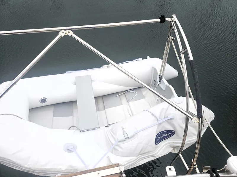 Slide: The Image of White inflatable dinghy on Island Packet 35 sailboat, 1990 model, secured with metal davits. - 29