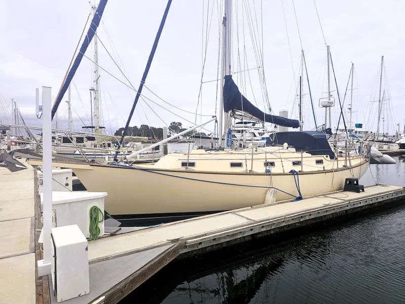 Slide: The Image of 1990 Island Packet 35 sailboat docked at marina, featuring classic design and beige hull. - 32
