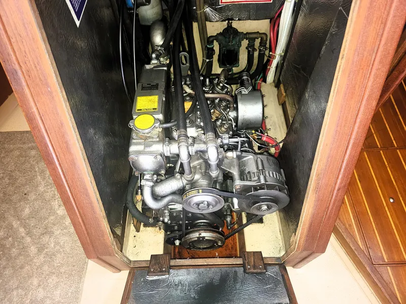 Slide: The Image of Engine compartment of a 1990 Island Packet 35 sailboat, showcasing mechanical components. - 33