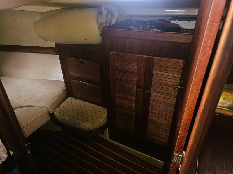 Slide: The Image of 1990 Island Packet 35 cabin interior with wooden cabinetry and cushioned seating. - 7