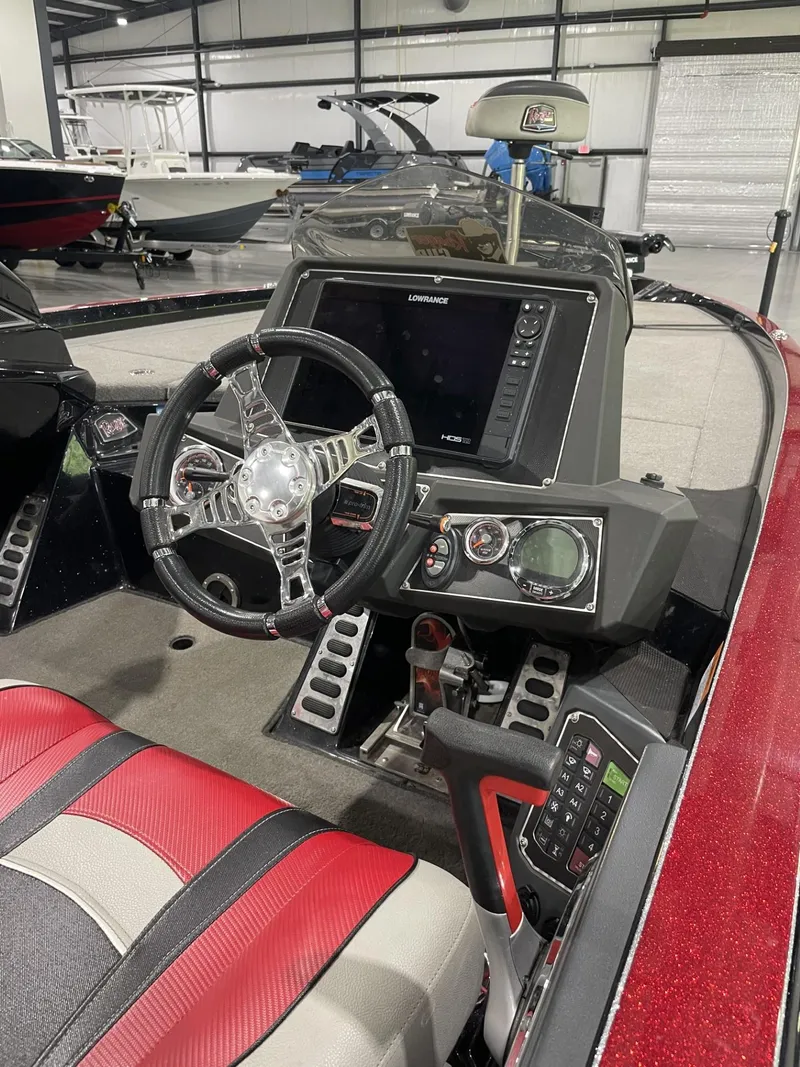 Slide: The Image of 2021 Ranger Z521L boat cockpit with steering wheel, control panel, and red-accented seating. - 4