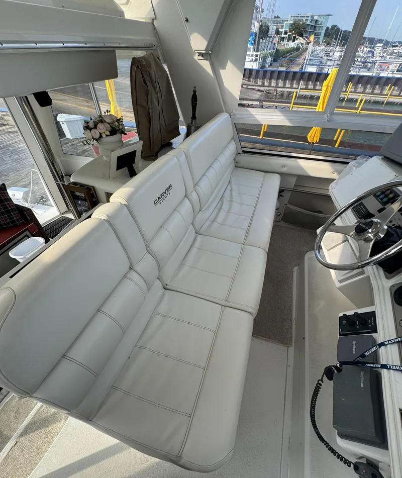 Slide: The Image of 2000 Carver 504 Cockpit Motor Yacht interior with white leather seating and helm. - 19