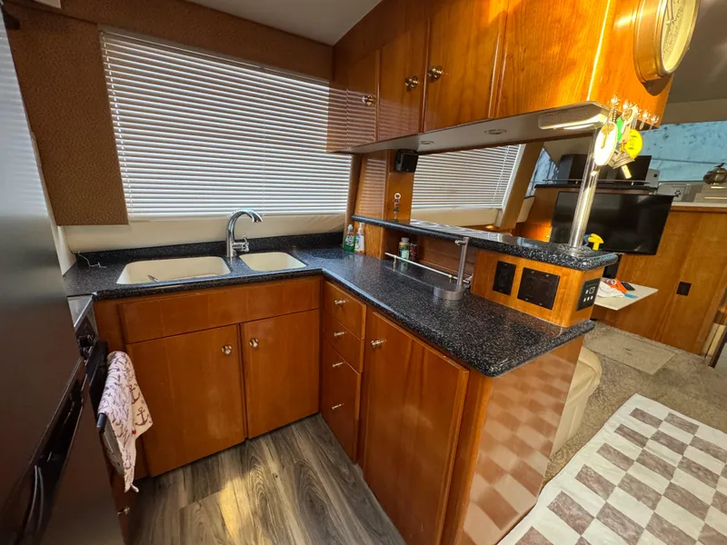 Slide: The Image of Kitchen area of 2000 Carver 504 Cockpit Motor Yacht with wood cabinets and modern appliances. - 24