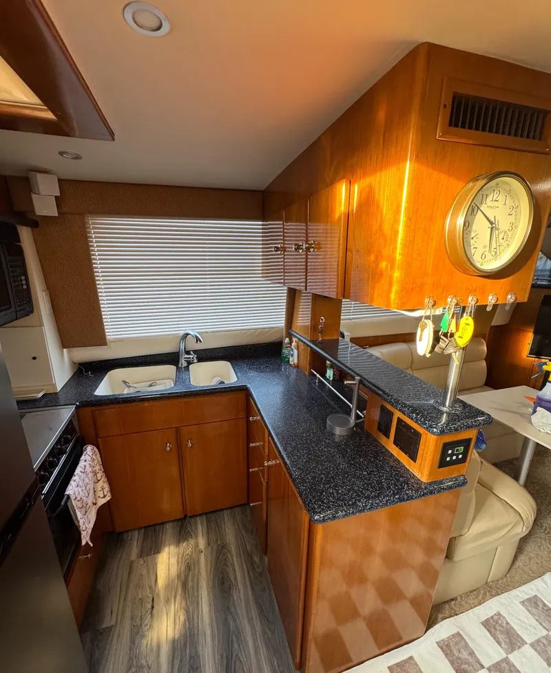Slide: The Image of Interior of 2000 Carver 504 Cockpit Motor Yacht kitchen with wood cabinets and granite countertops. - 25