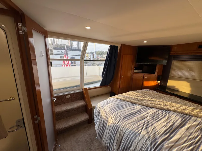 Slide: The Image of Interior of 2000 Carver 504 Cockpit Motor Yacht bedroom with bed, TV, and window view. - 43