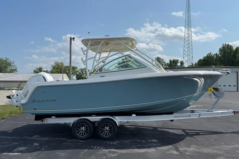 The Image of 2025 Sailfish 245 DC boat on trailer, parked outdoors under clear sky. - 0