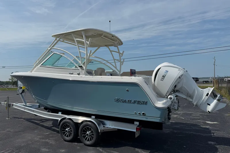 Slide: The Image of 2025 Sailfish 245 DC boat on trailer with Yamaha outboard motor, parked outdoors. - 4