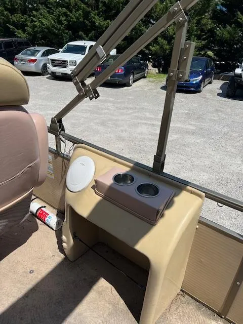 Slide: The Image of 2008 Godfrey SANPAN 2500 DC interior with cup holders and outdoor parking view. - 8